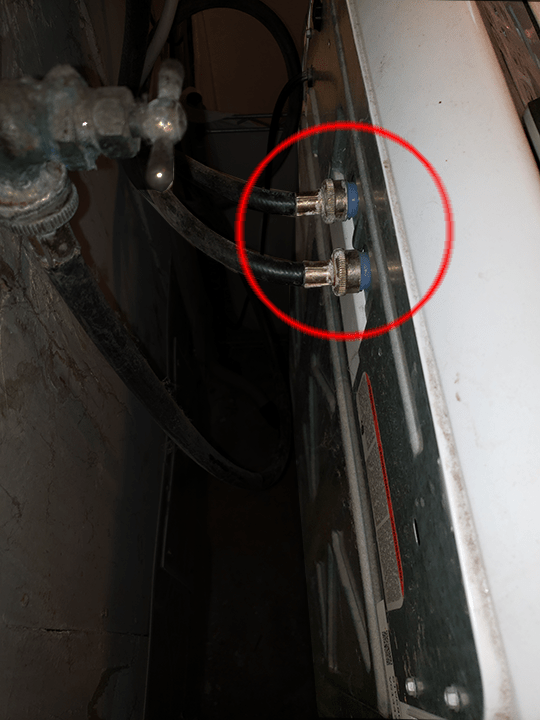 The hot and cold water input hoses are at the back of the machine, at the top. You'll need to use pliers to turn them counterclockwise.